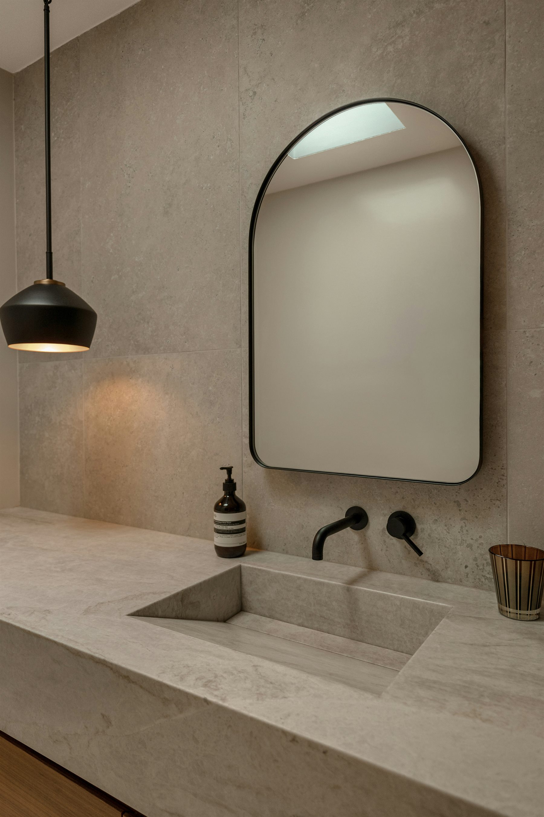 Editorial concrete vanity and arched mirror