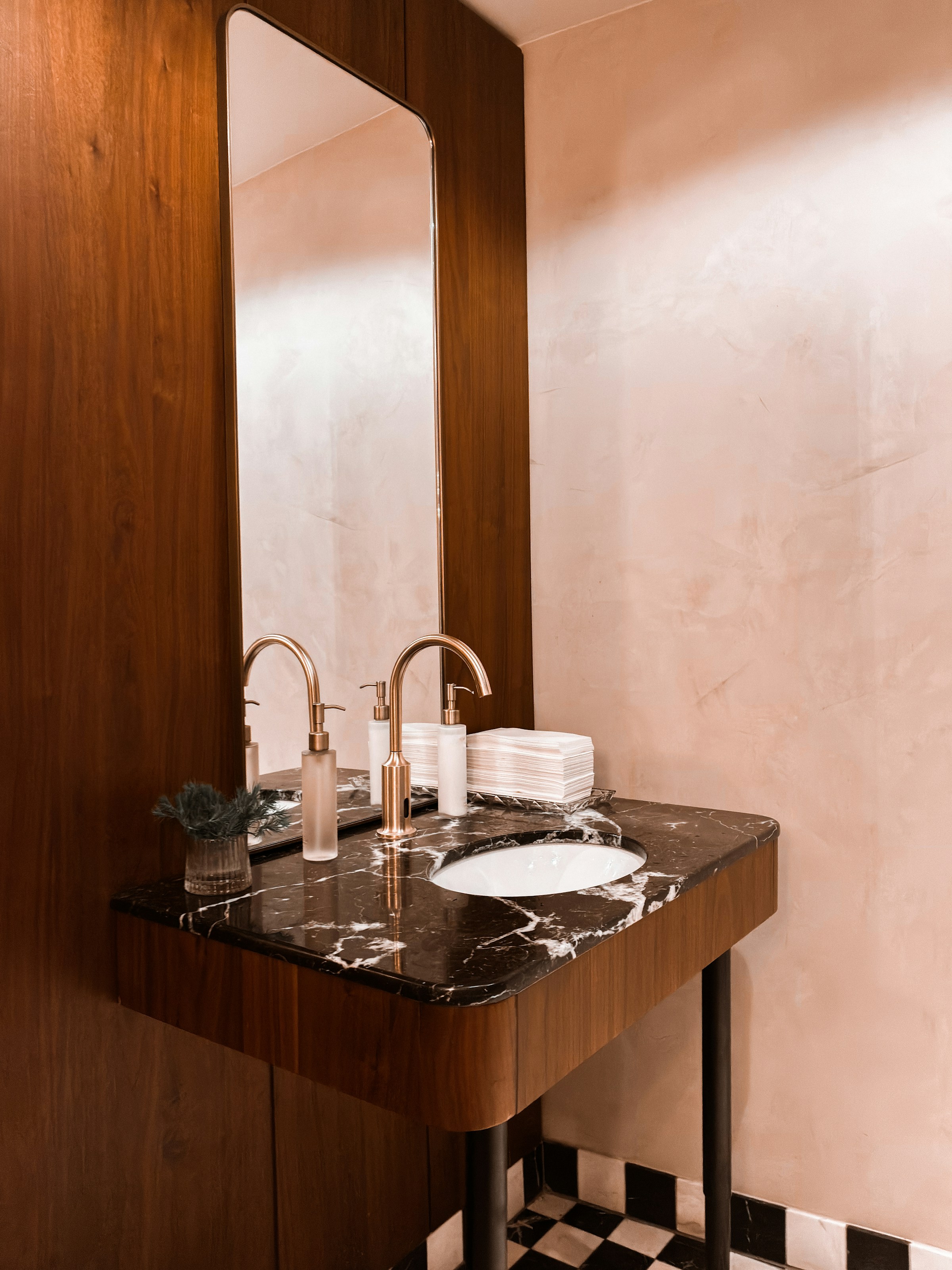 Warm timber vanity with marble top and brass tap